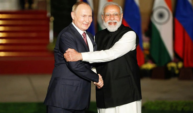Vladimir Putin shakes hands with Narendra Modi